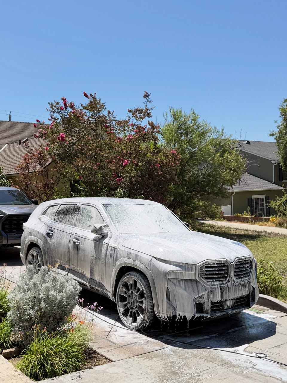 SUV covered in snow foam during a mobile car wash in a Peninsula driveway